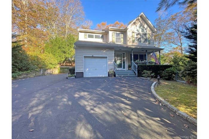 Traditional-style house with covered porch and asphalt driveway