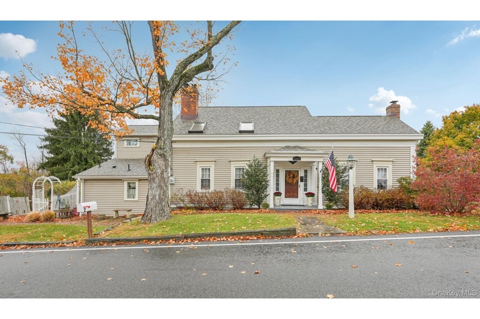 View of front of house with a chimney and a shingled roof