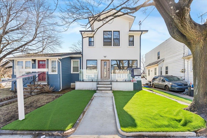 View of front of home featuring a front lawn and stucco siding