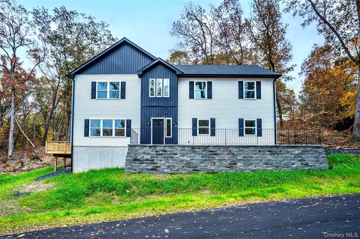 View of front of house featuring a wooden deck