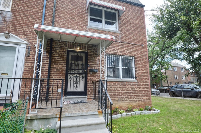 Entrance to property with brick siding and a yard