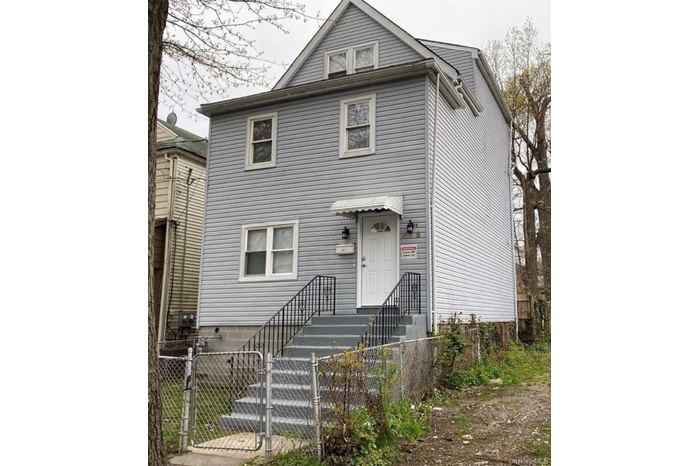 Traditional style home with a gate and a fenced front yard