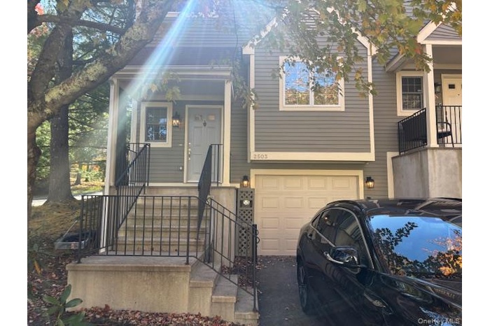 View of front of property featuring an attached garage and driveway