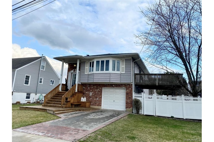 Split foyer home featuring brick siding, driveway, and a garage