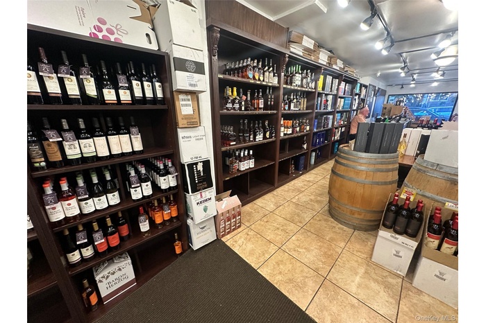 Wine area featuring rail lighting and light tile patterned floors
