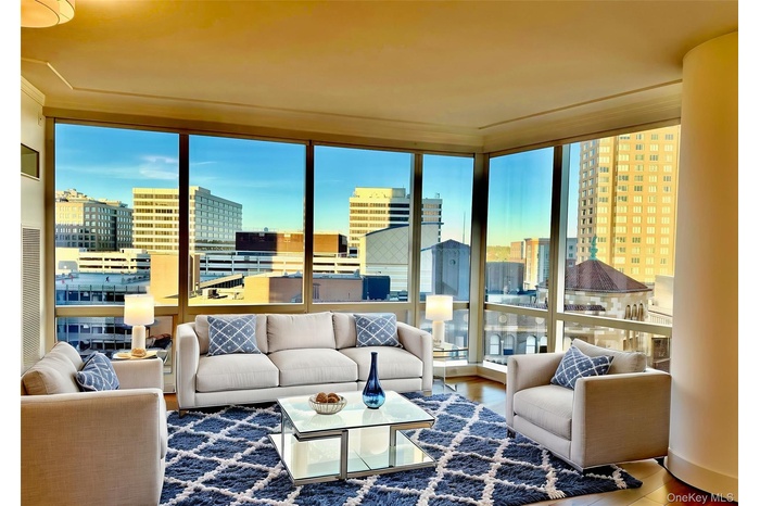 Living area featuring a city view, wood finished floors, and a wall of windows