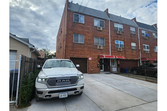 View of property featuring driveway and a garage