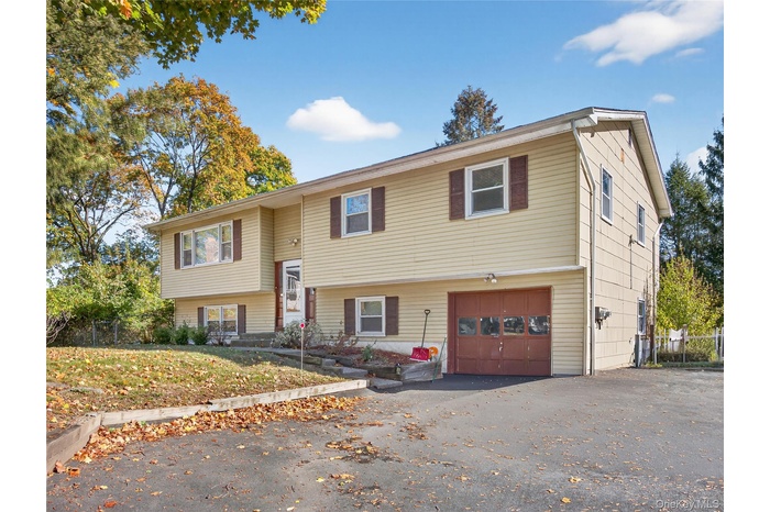 Split foyer home with an attached garage and driveway