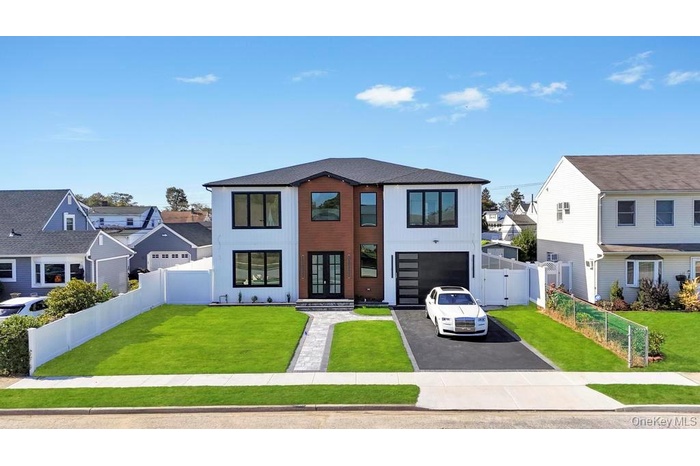 View of front of house with asphalt driveway, a garage, and a residential view