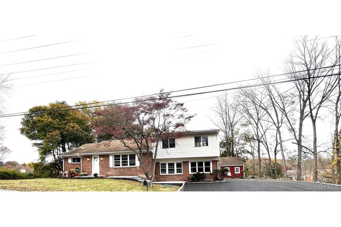 Tri-level home featuring brick siding and a front yard