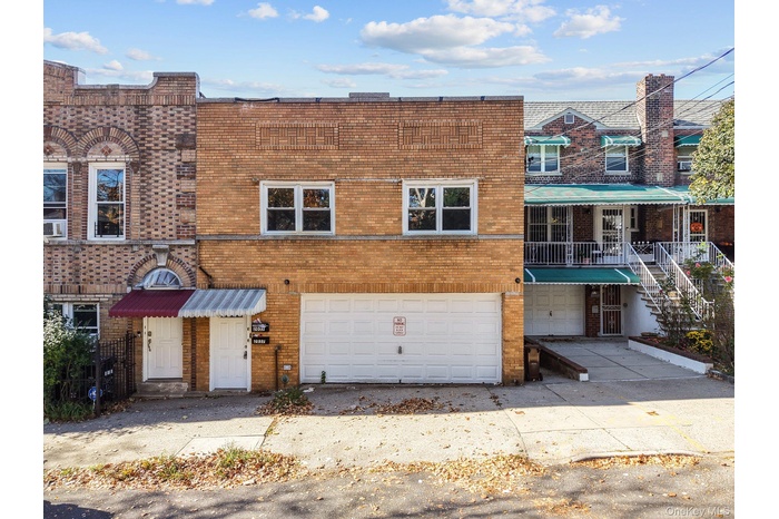 Traditional-style house featuring brick siding, a garage, concrete driveway, and stairway