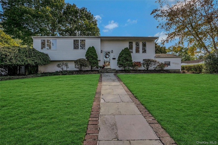 Split foyer home featuring a front yard