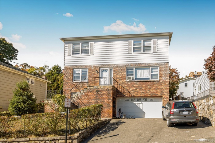 Traditional-style house with brick siding and driveway