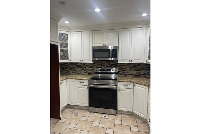 Kitchen featuring stainless steel appliances, white cabinetry, tasteful backsplash, and recessed lighting