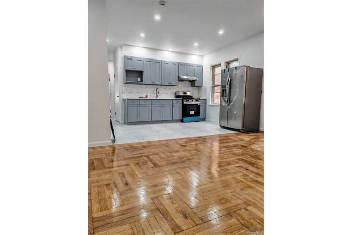 Kitchen with stainless steel appliances, backsplash, light countertops, recessed lighting, and under cabinet range hood