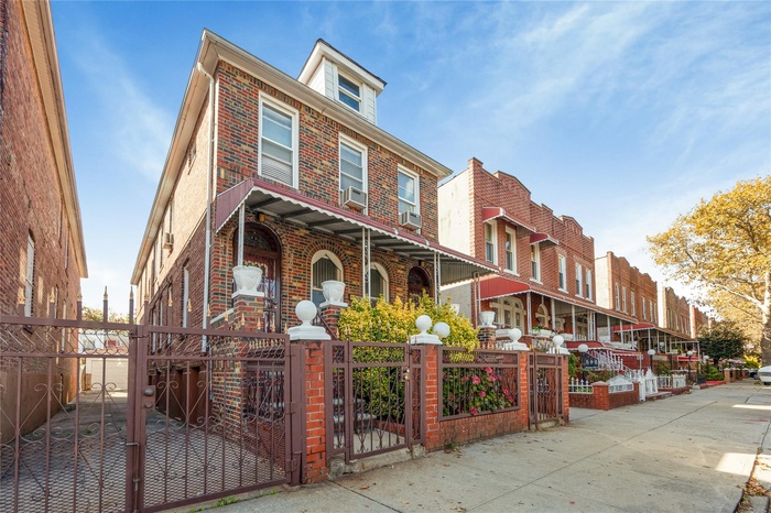 View of front of house featuring a gate, brick siding, and a fenced front yard