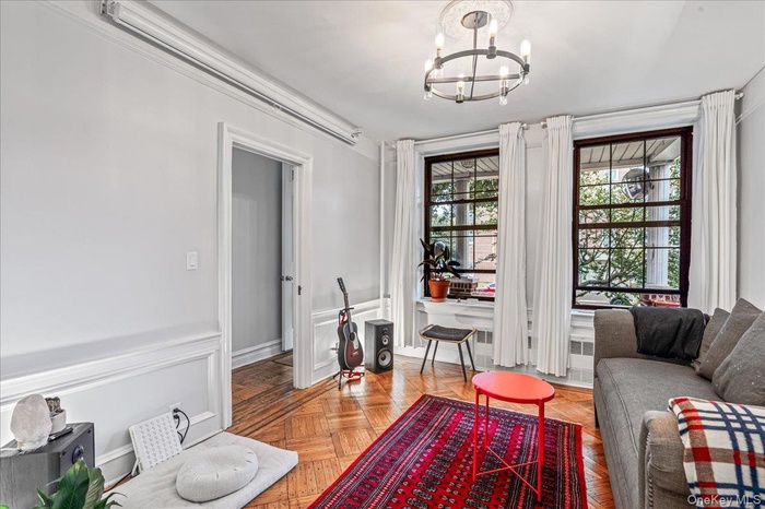 Sitting room featuring a chandelier, a decorative wall, and a wainscoted wall