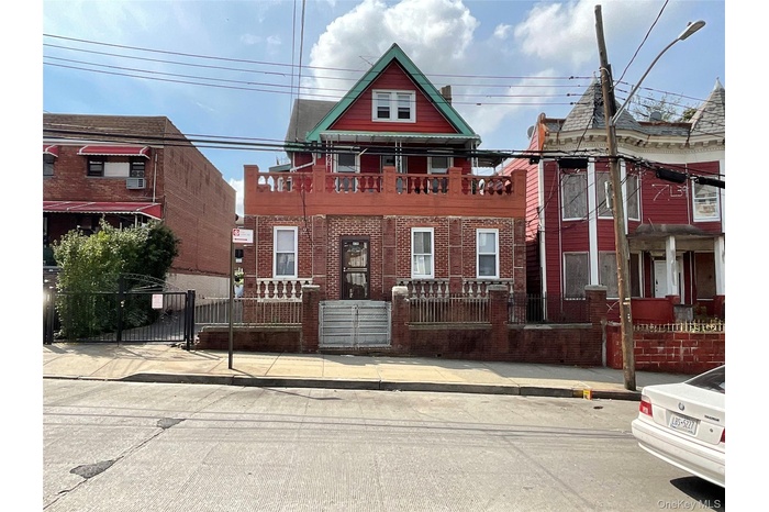 View of front of property with a fenced front yard, brick siding, and a gate