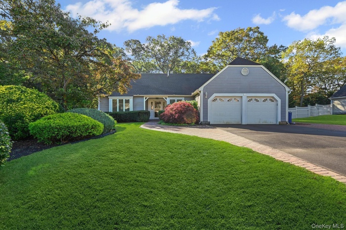 View of front of house with asphalt driveway and an attached garage