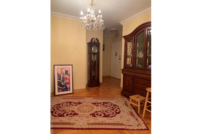 Hallway featuring ornamental molding and a chandelier