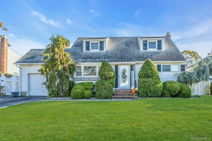 View of front of house featuring driveway, and one car garage