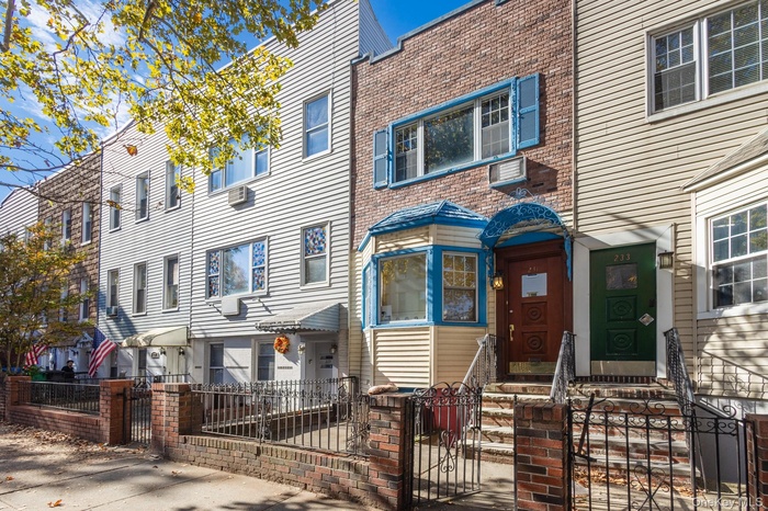 View of front of home featuring a gate, a fenced front yard, brick siding, and a residential view