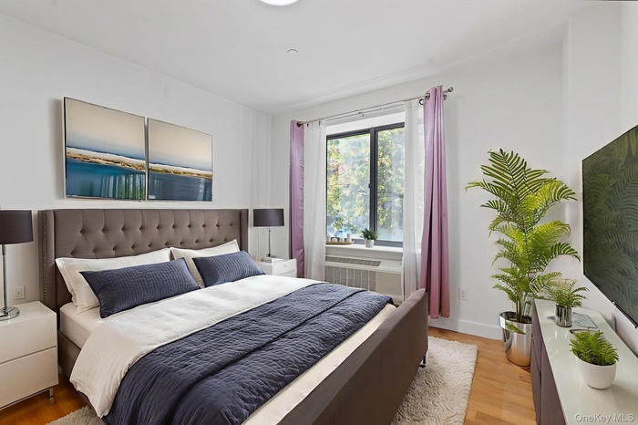 Bedroom featuring wood finished floors and radiator