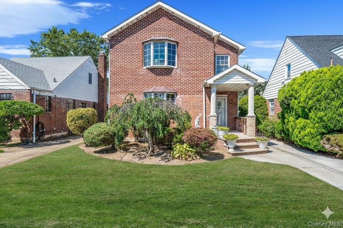View of front of home with a front lawn and brick siding