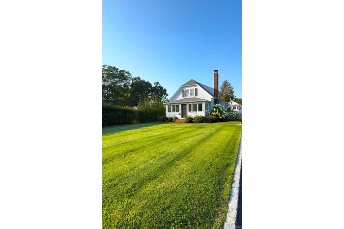 View of front of house featuring a front lawn and a chimney