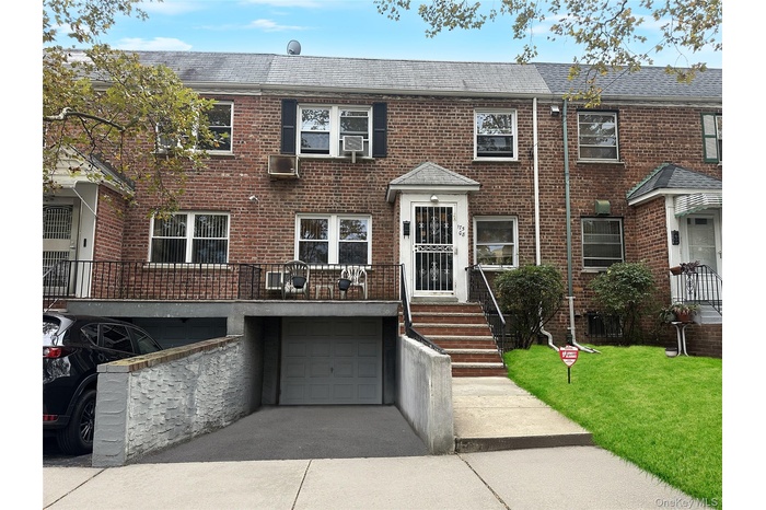 Colonial house featuring brick siding, a shingled roof, and driveway