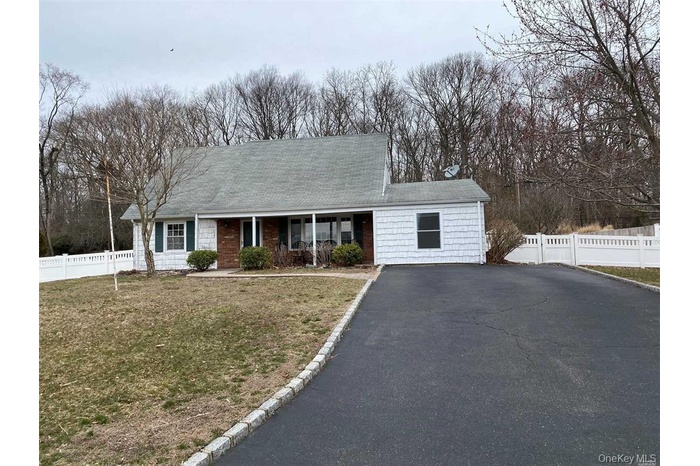 View of front of house featuring covered porch, driveway, and roof with shingles