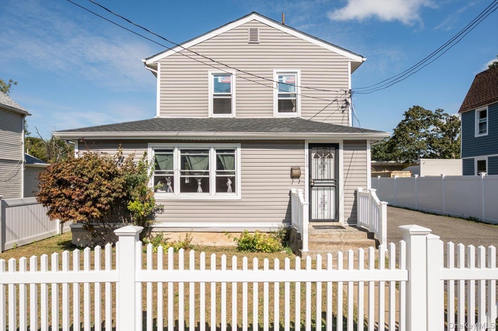 View of front of house featuring roof with shingles and a fenced front yard