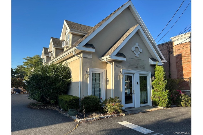 View of front of home with a shingled roof and stucco siding