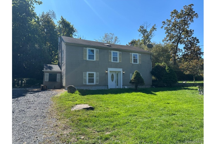 Colonial-style house featuring a front lawn