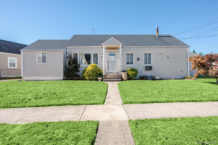 View of front of home featuring a shingled roof and a front yard