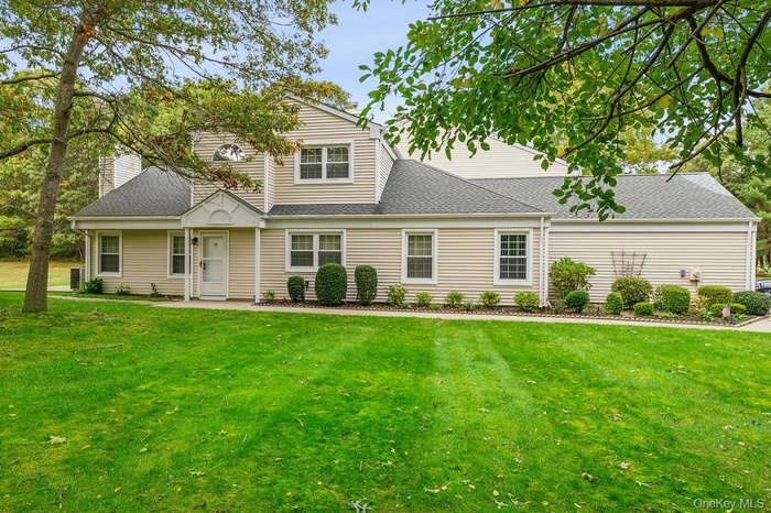 View of front of house featuring a shingled roof, a front lawn, and a chimney