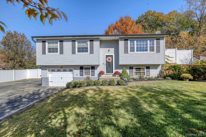 Split foyer home featuring asphalt driveway and an attached garage