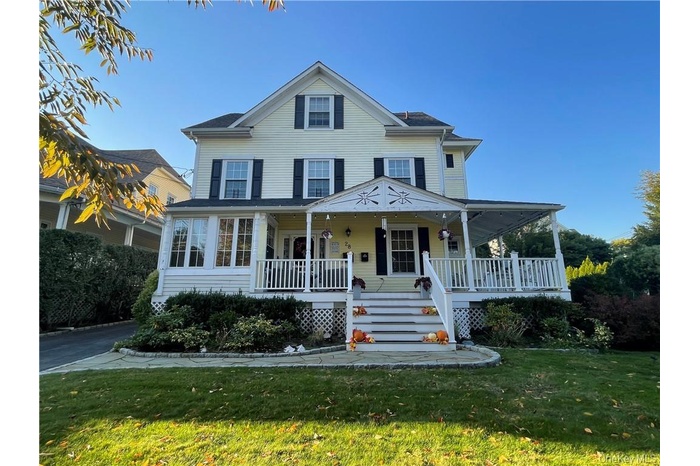 View of front facade featuring covered porch and a front lawn