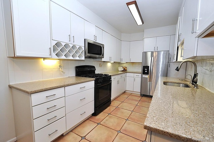 The oversized Eat-in-Kitchen has over 20' of granite counters, custom cabinets, dishwasher, range, microwave, refrigerator, built-in wine rack and a w