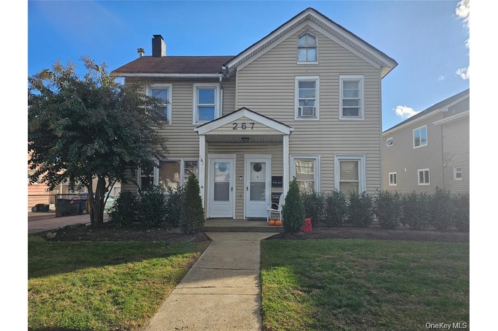 Traditional home with a front lawn and a chimney
