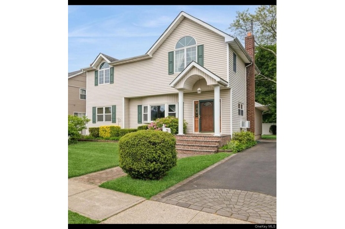 View of front facade featuring a chimney and a front yard
