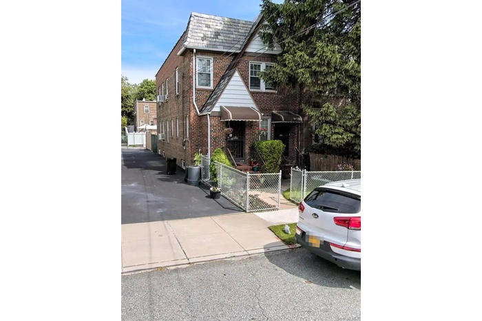 View of front facade featuring a fenced front yard, a gate, and brick siding