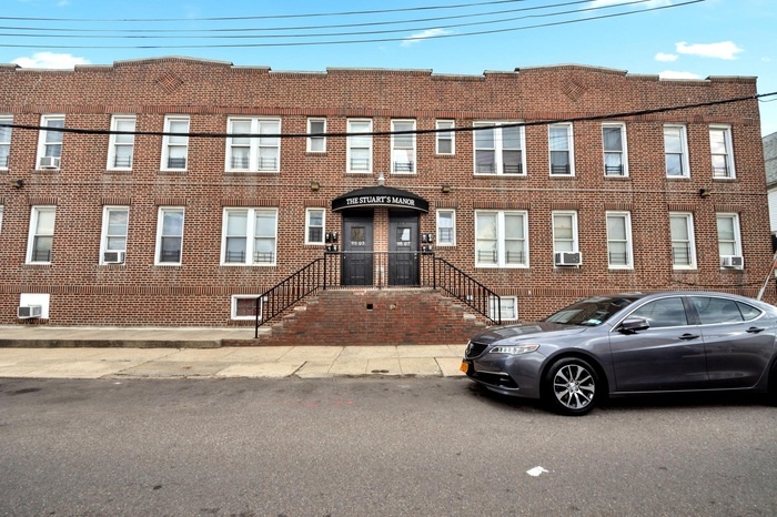View of front of house featuring cooling unit and brick siding