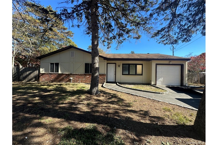 Ranch-style house featuring brick siding, an attached garage, and driveway