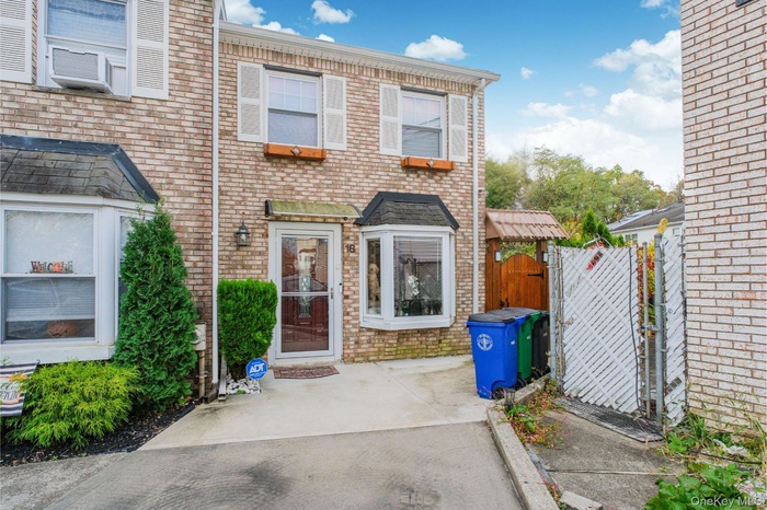 View of front of home with a gate and brick siding