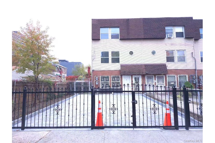View of front facade featuring brick siding, a fenced front yard, and roof with shingles