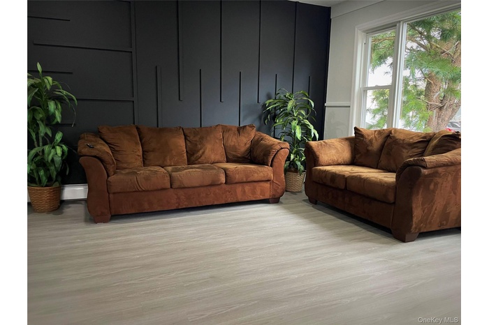 Living area featuring light wood finished floors and a decorative wall