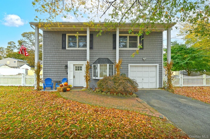 View of front of home with asphalt driveway and a garage