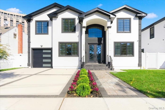 View of front of home with stucco siding, driveway, and an attached garage