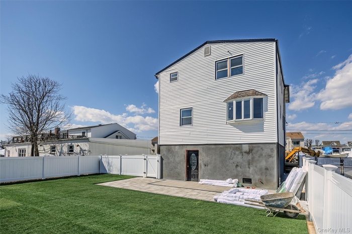 Back of property featuring a fenced backyard, a gate, a patio, and stucco siding